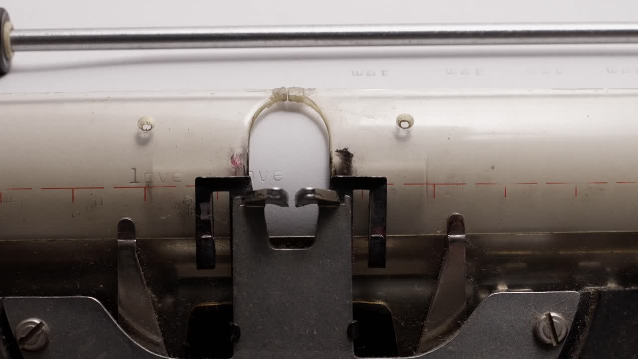 Detailed close-up of vintage typewriter typing the word "love" on paper