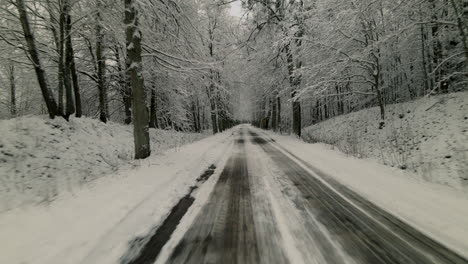 Viajar-A-Través-De-La-Carretera-Rural-En-El-Bosque-De-Invierno-Nevado-Cerca-Del-Pueblo-De-Pieszkowo,-Polonia