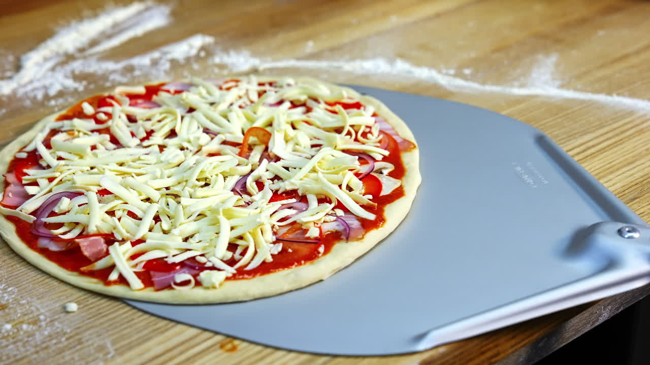 Half ready pizza with cheese, mushrooms, bakon and tomato souce. Pizza ready to be baked in an oven. Food video concept.