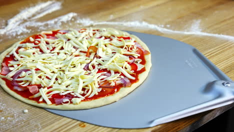 half ready pizza with cheese, mushrooms, bakon and tomato souce. pizza ready to be baked in an oven. food video concept.