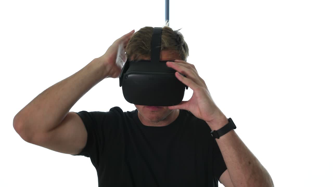 un joven caucásico se pone gafas de realidad virtual y mira a su alrededor en 4k