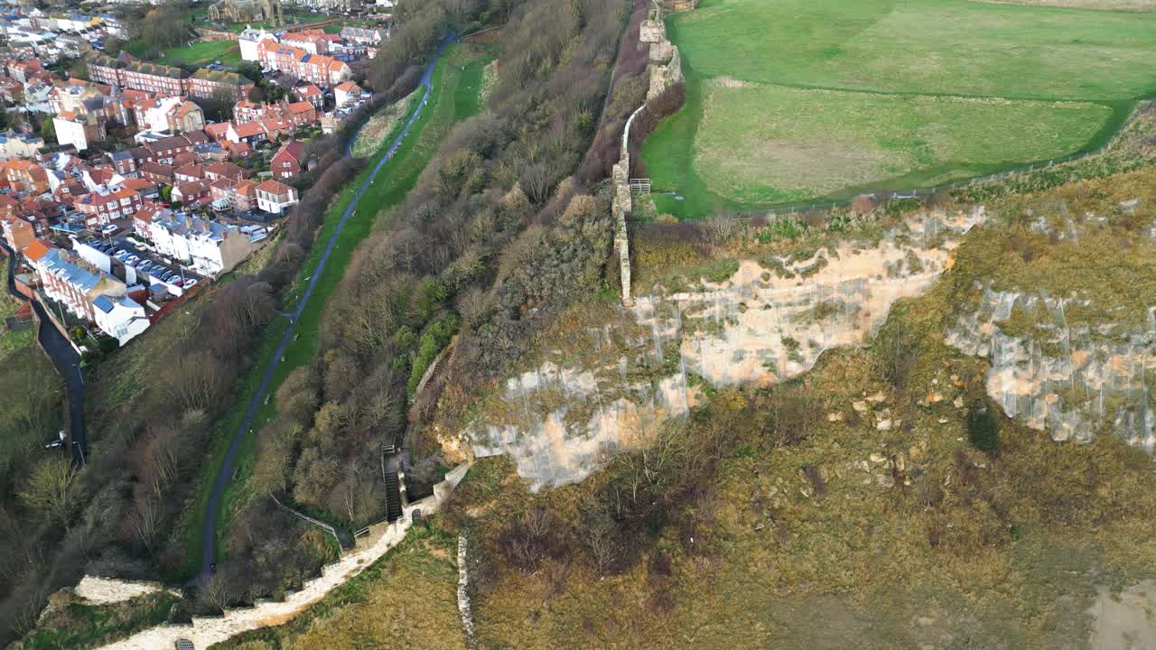 drone aéreo disparado sobre casas de la ciudad junto a la vegetación verde exuberante en scarborough en el norte de yorkshire, inglaterra, reino unido