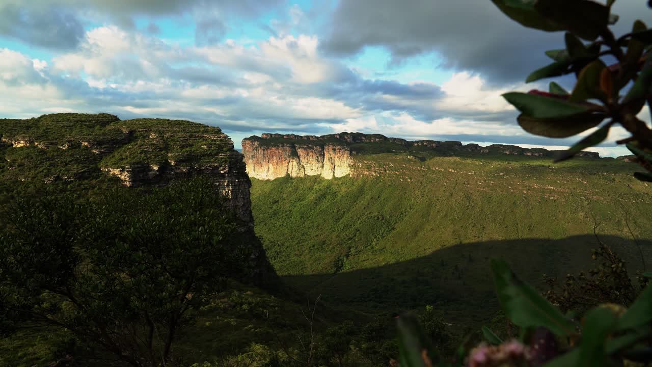 Panning left shot revealing the stunning Capao Valley with large plateaus from the Mount of Pai Inácio hike in the Chapada Diamantina national park in northern Brazil on a warm summer evening
