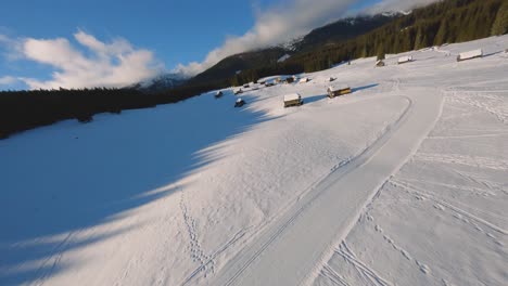 Fpv-drohnenaufnahme,-Aufgenommen-In-Slowenien-Im-Pokljuka-wald-Mit-Umliegender-Natur-Und-Bergen-Zur-Goldenen-Stunde-Bei-Sonnenuntergang-Mit-Schneller-Und-Filmischer-Bewegung-Um-Das-Dorf-Und-Den-Wald