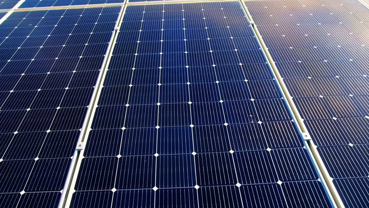 Vista aerea da drone di diversi pannelli solari sul tetto di un edificio industriale. Temi relativi all'ecologia
