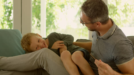 father and son having fun on sofa 4k