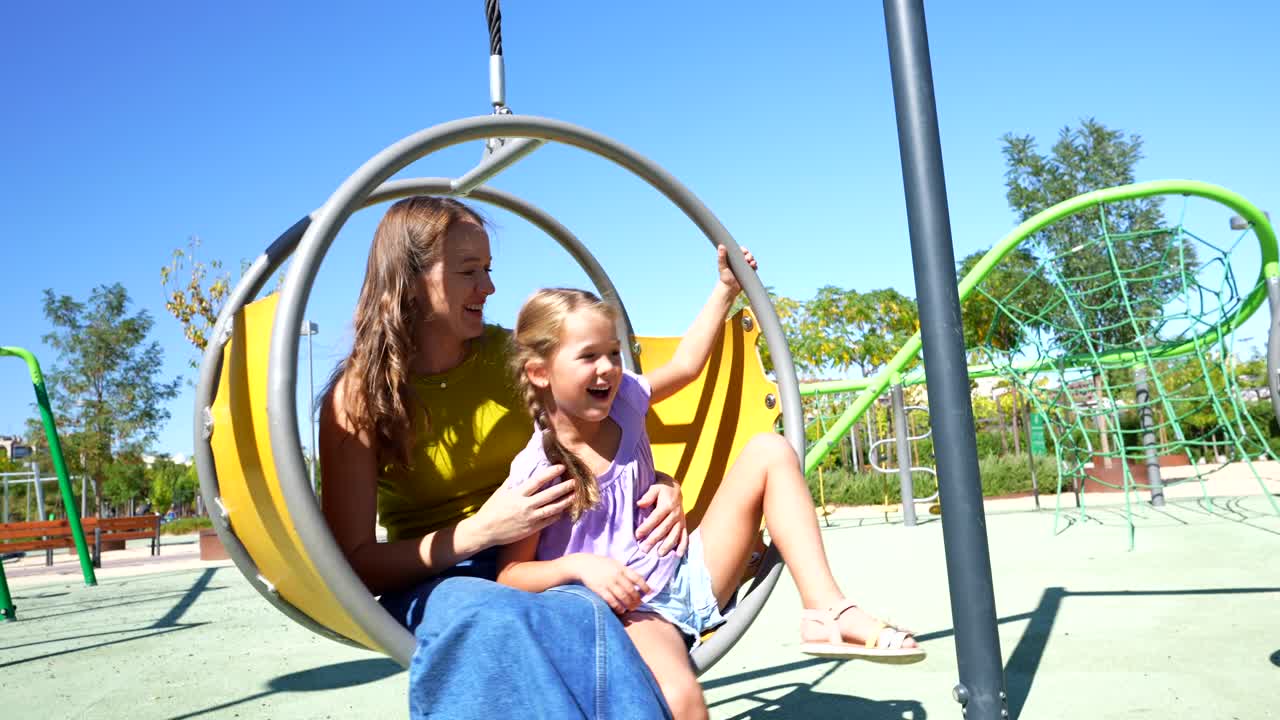 Mother and Child Playing on a Swing in a Playground