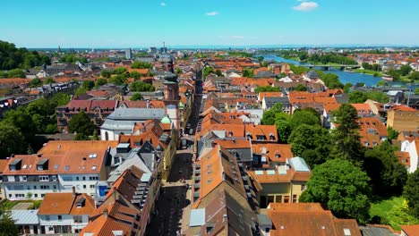 4k aerial drone video of historic homes, shops, and churches along the neckar river in downtown heidelberg, germany