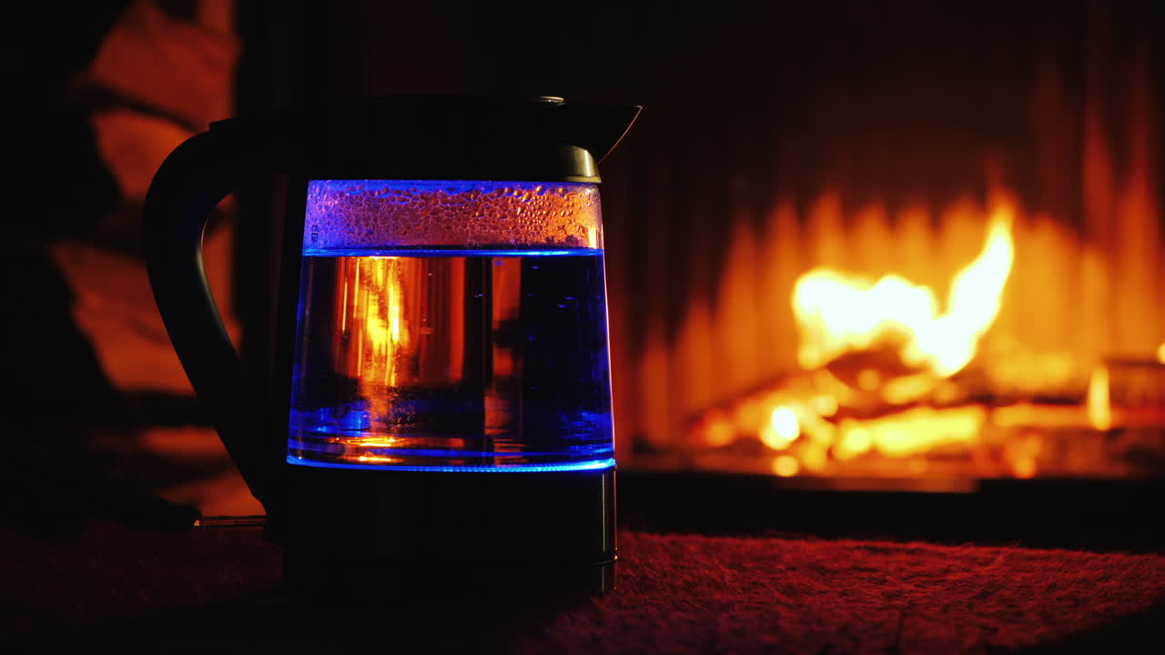 역광 전기 주전자에 물이 끓는다 배경에 있는 불이 배경에서 타오른다