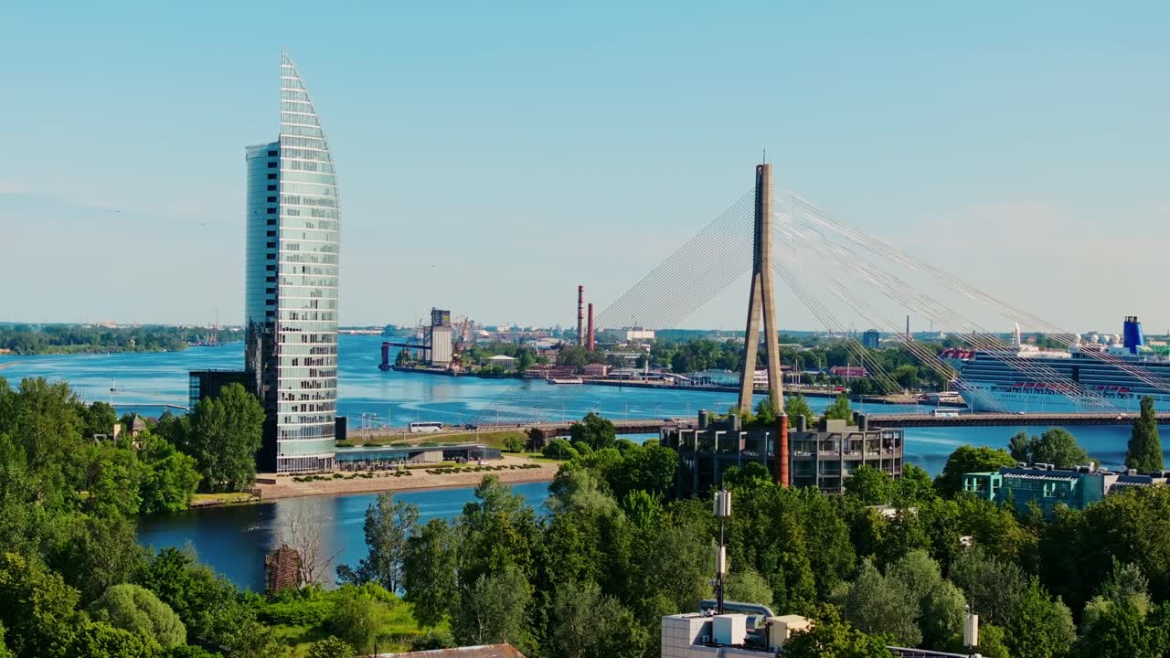 Modern Riga bridge and tower seen from drone flying forward in summer sunlight