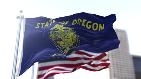 the flags of the oregon state and united states waving in the wind