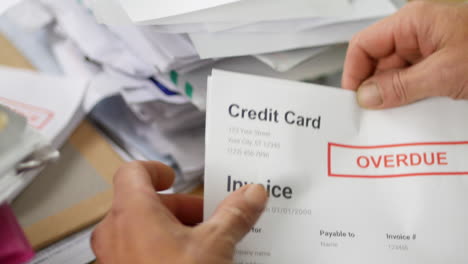 close up of a man opening debt letters