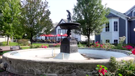 empty fountain on a sunny afternoon surrounded with flowers, wide shot