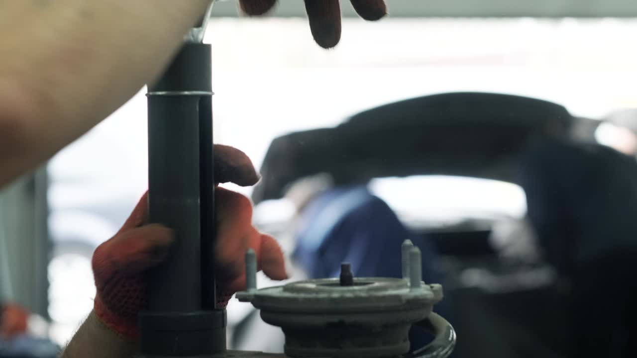 자동차 수리 공장에서 자동차 충격 흡수기를 작업하는 자동차 기계공