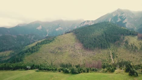 Forward-drone-shot-over-a-valley-next-to-mountains