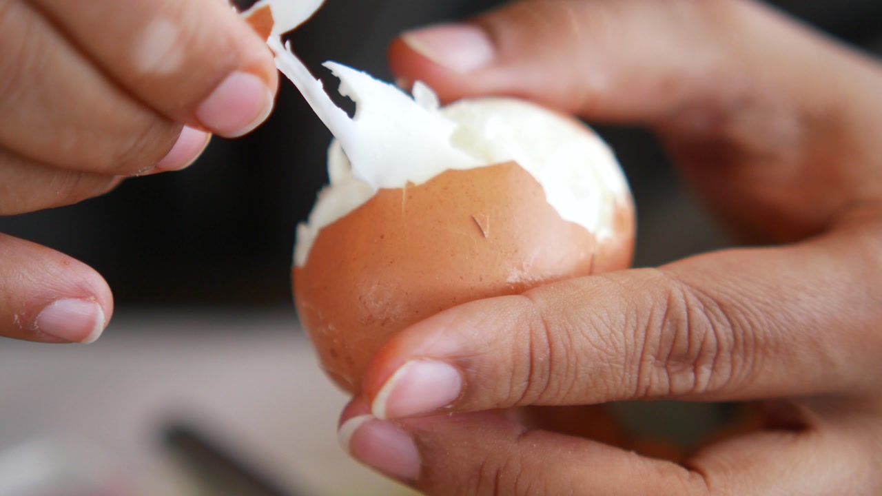 Close-up of Hands Peeling a Hard-Boiled Egg