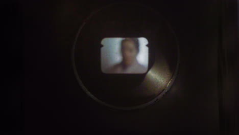 woman on camera through old dirty 8mm viewfinder with film strip effect and flares