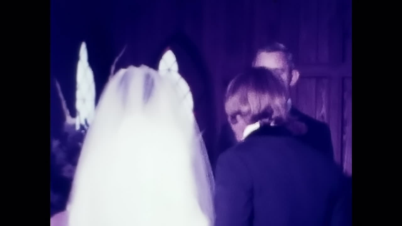Man in Suit and Tie Standing Next to Woman in Wedding Dress at 1970s Wedding. CIRCA USA - 1970s: Vintage archival photo showcasing a man wearing a suit and tie standing alongside a woman in a wedding dress during a 1970s wedding in the USA.
