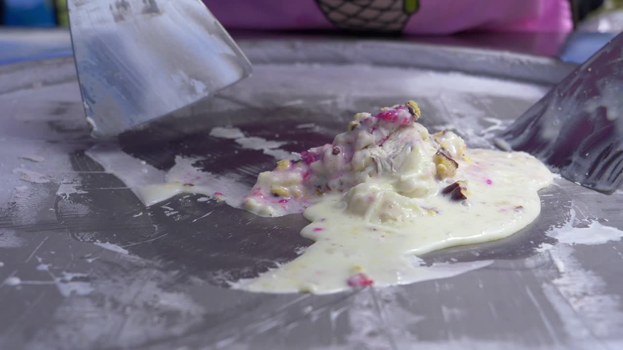 el confitero usa espátulas para preparar la mezcla para el postre de helado