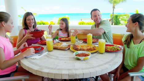 family eating lunch on deck of beach resort