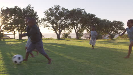 elementary school kids playing football in a field