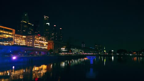 Panoramic-view-of-the-reflection-of-the-lights-of-the-exclusive-restaurants-on-the-river-in-Puerto-Madero,-Buenos-Aires