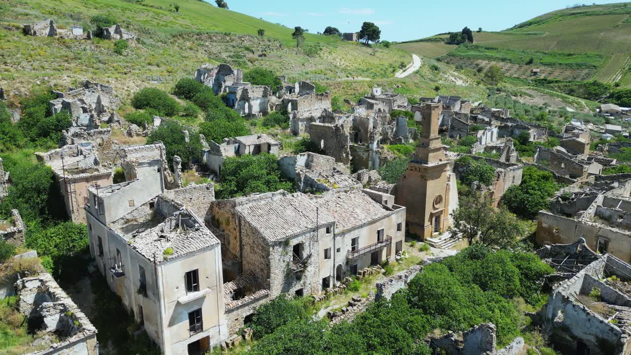 Aerial drone footage of old Poggioreale, Sicily: abandoned ghost town destroyed by the 1968 earthquake, surrounded by hills and silence. Ideal for history, decay, and documentary projects