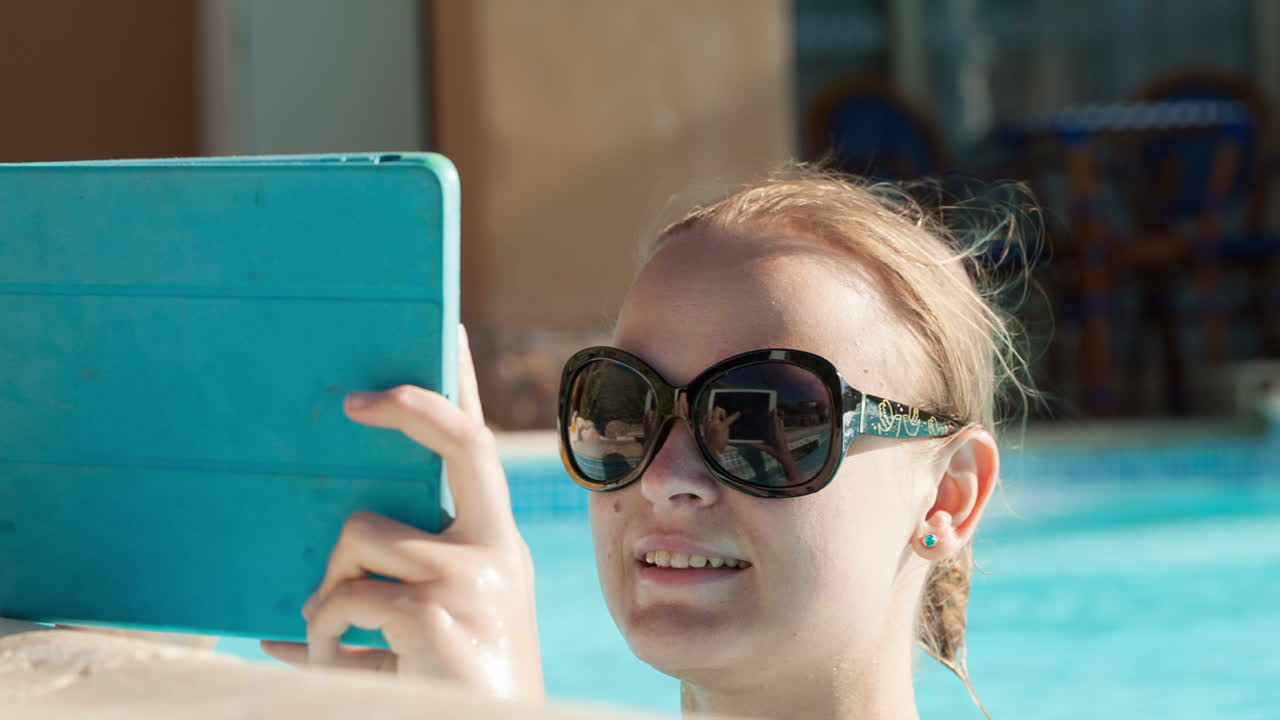 Young woman using a tablet poolside