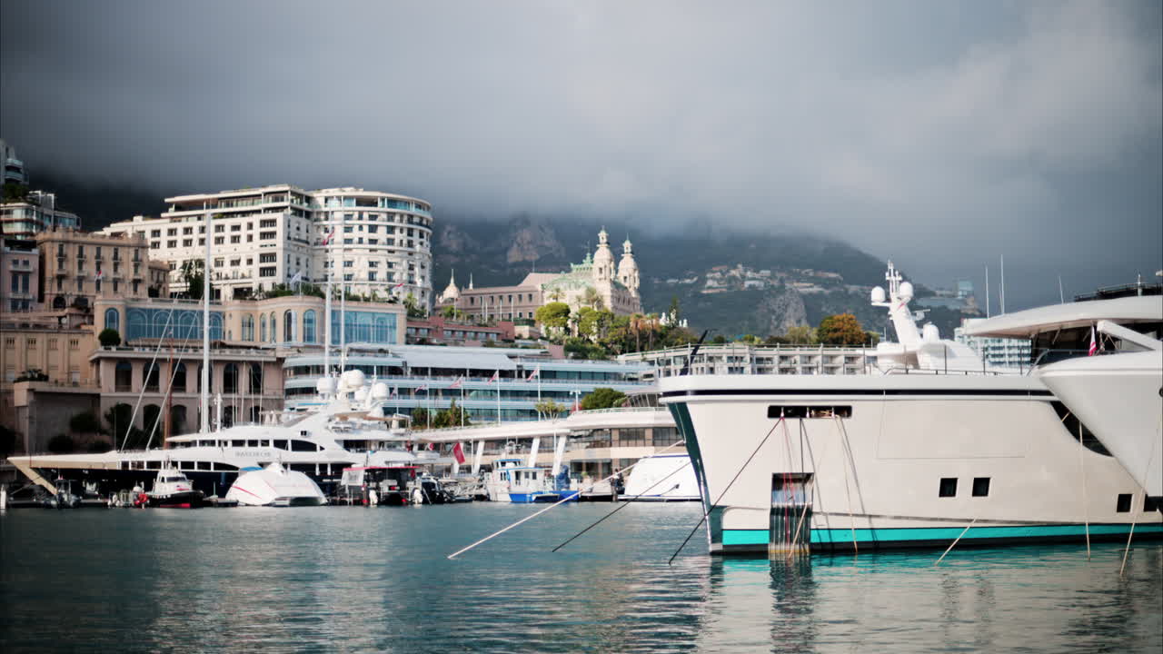 View of boats docked in the Monaco Marina with the skyline of the city on the background