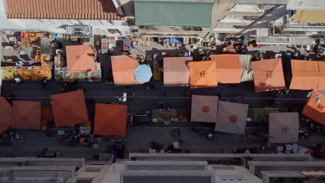 aerial drone shot looking down street with busy street market athens greece