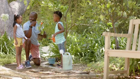 Felices-Hermanos-Afroamericanos-Con-El-Abuelo-Hablando-En-El-Jardín,-En-Cámara-Lenta