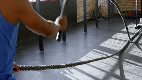 senior man doing crossfit rope training in the fitness studio 4k