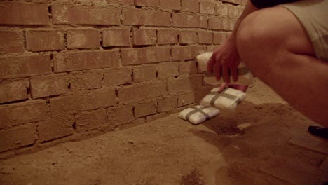 hombre colocando paquetes de cocaína en polvo en almacenamiento oculto