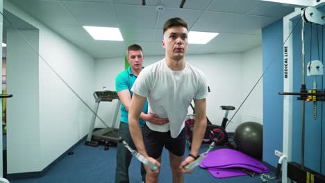 physiotherapist helping patient. physiotherapist working with male patient in modern clinic