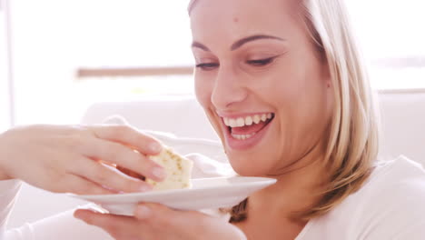 cerca de una mujer sonriente comiendo un pastel