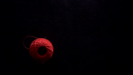 color thread ball fall down in slow motion black background static