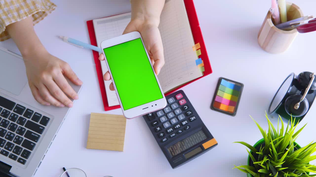 Business woman using smartphone with green screen