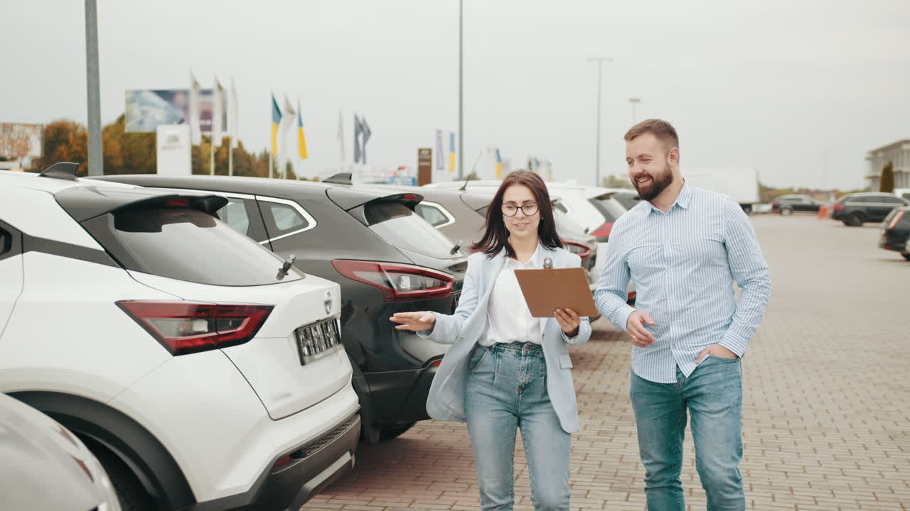 자동차 판매자 가 고객 과 차량 에 대해 논의 하고 있다