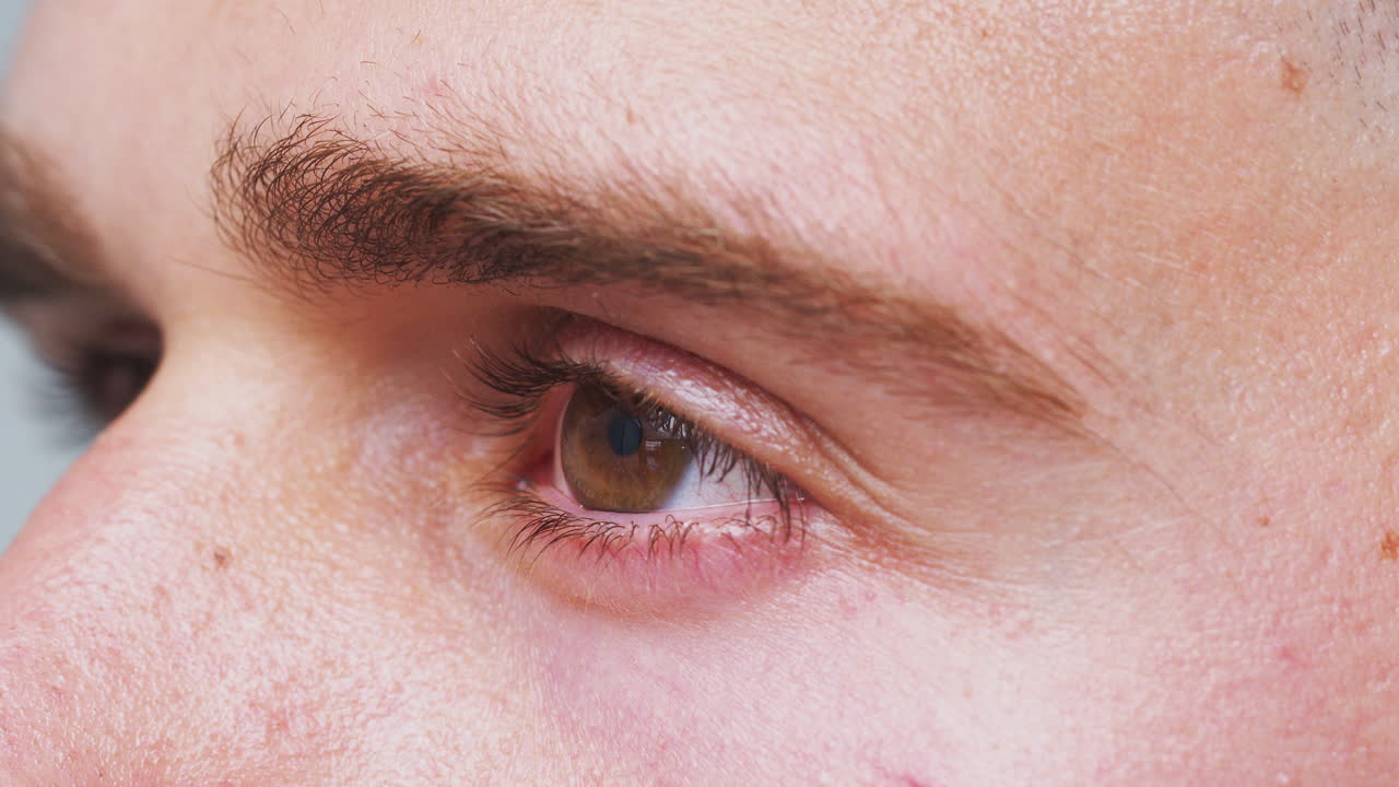 남자가 스튜디오에서 카메라를 바라볼 때 눈이 열리고 닫히는 극단적인 클로즈업