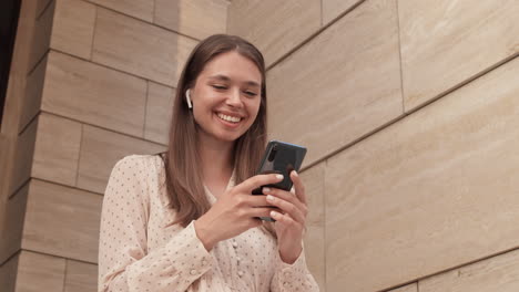 woman using smartphone by building