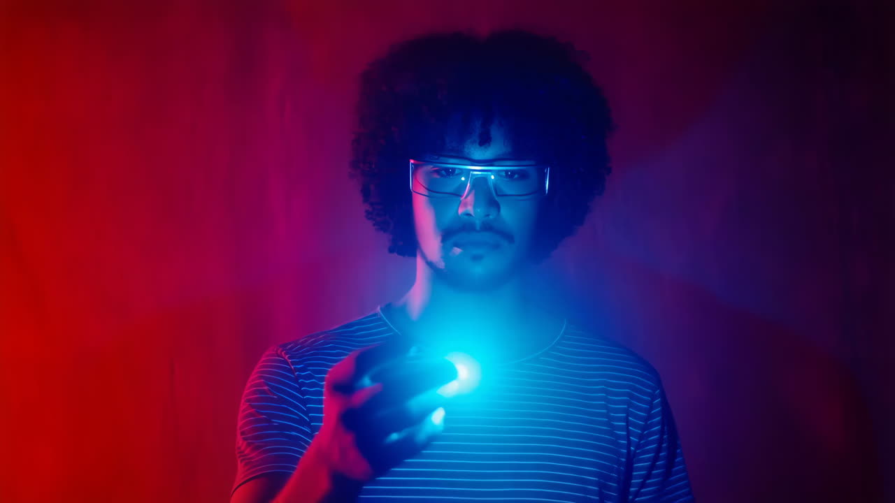 Uomo con occhiali futuristici che tiene un oggetto luminoso in luce rossa e blu