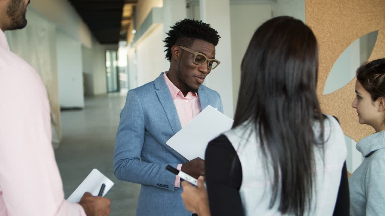 Smiling African American man talking with colleagues