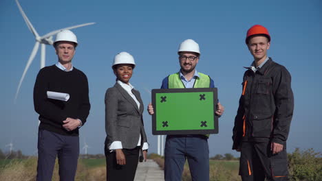 team of engineers with green screen at wind farm