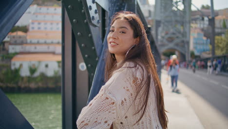 happy woman enjoying sunlight at city bridge closeup.  girl looking camera