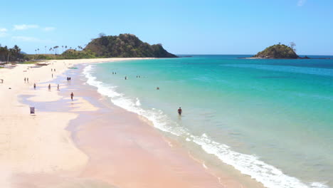 scenic tropical beach with turquoise water and people swimming