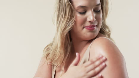 caucasian plus size woman with light skin and blonde hair touching her shoulder