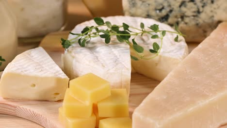 various cheeses and dairy items on wooden board