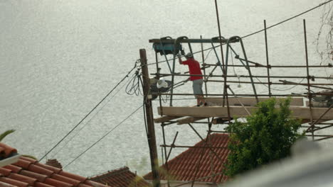 construction worker on scaffolding with sea view