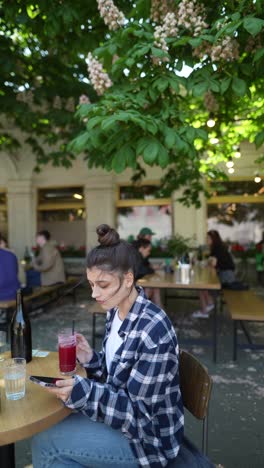 woman using phone in an outdoor cafe