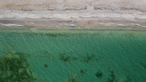 Ein-Unberührter-Strand-Mit-Türkisfarbenem-Wasser-Und-Sanften-Wellen,-Luftaufnahme